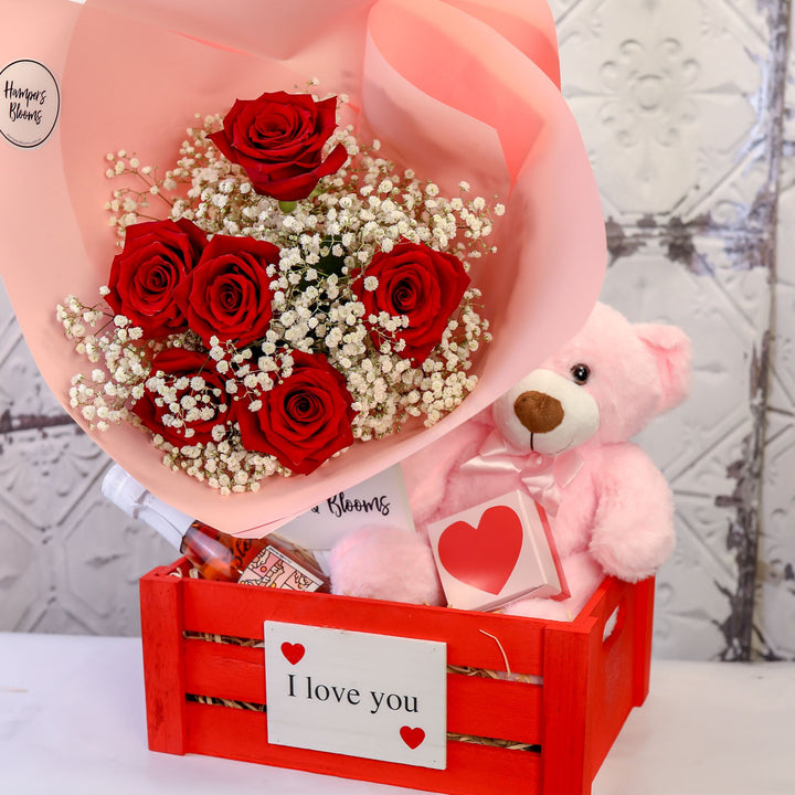 Red rose bouquet and pink teddy with a heart box in a medium red I love you crate
