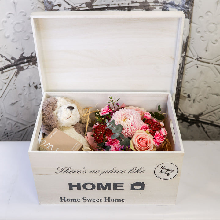 Open white keepsake chest with pink flowers, plush puppy and boxed candle inside